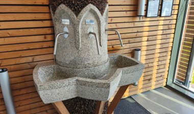 Brine drinking fountain in the Tourist Information building in the St. Jakob brine garden in Kevelaer with tap and stone collecting basin.