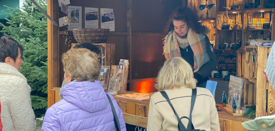 Visitors in front of a hut at the nativity scene market