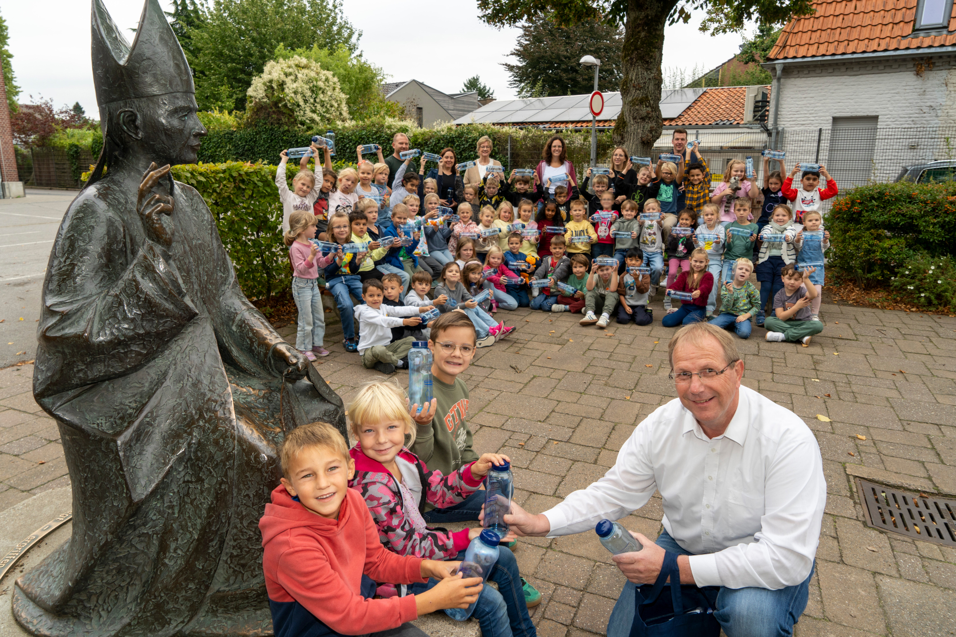 First graders at St. Hubertus Primary School with new drinking bottles, together with teachers and Wolfgang Toonen.