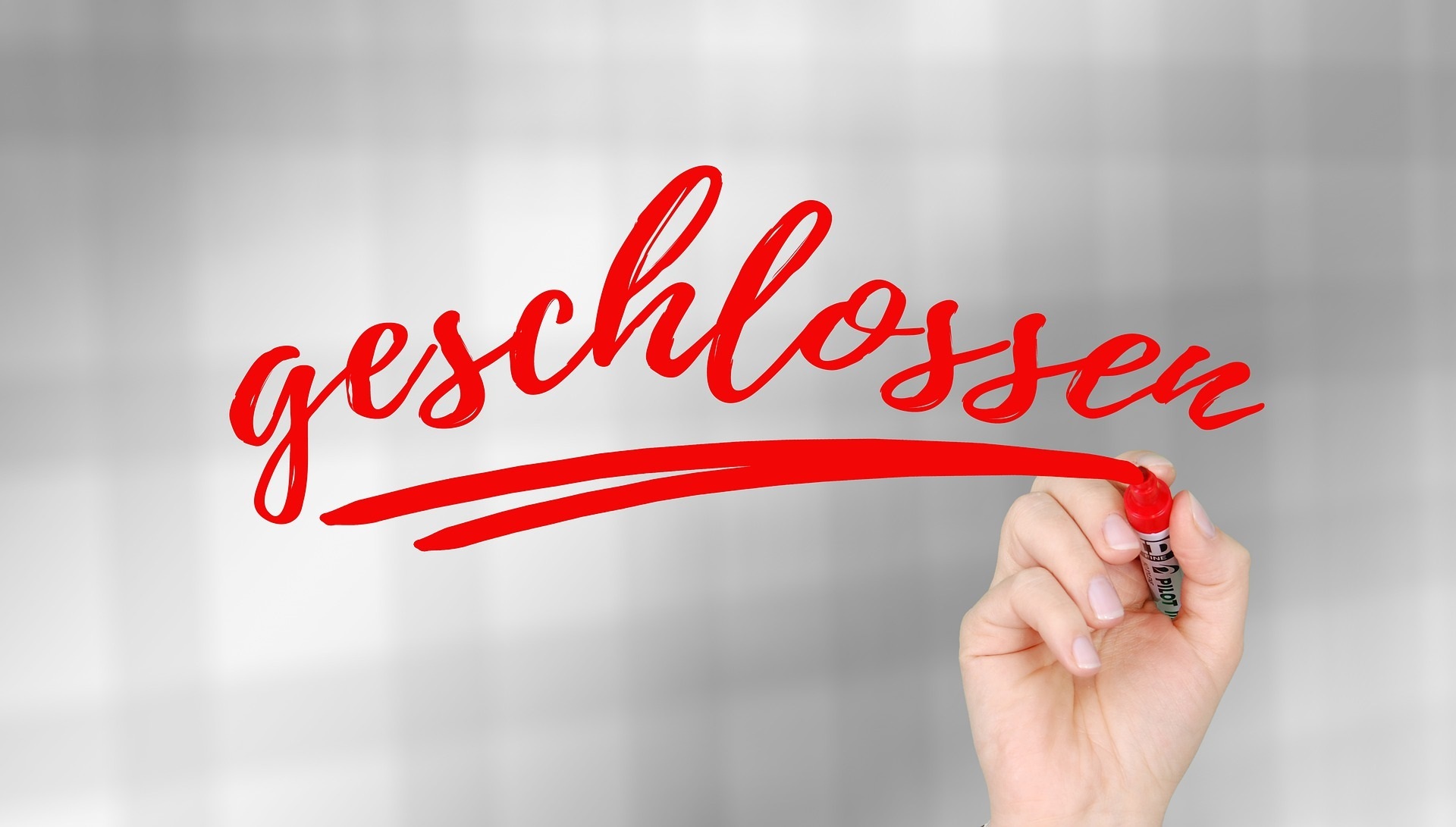 One hand writes the word "closed"