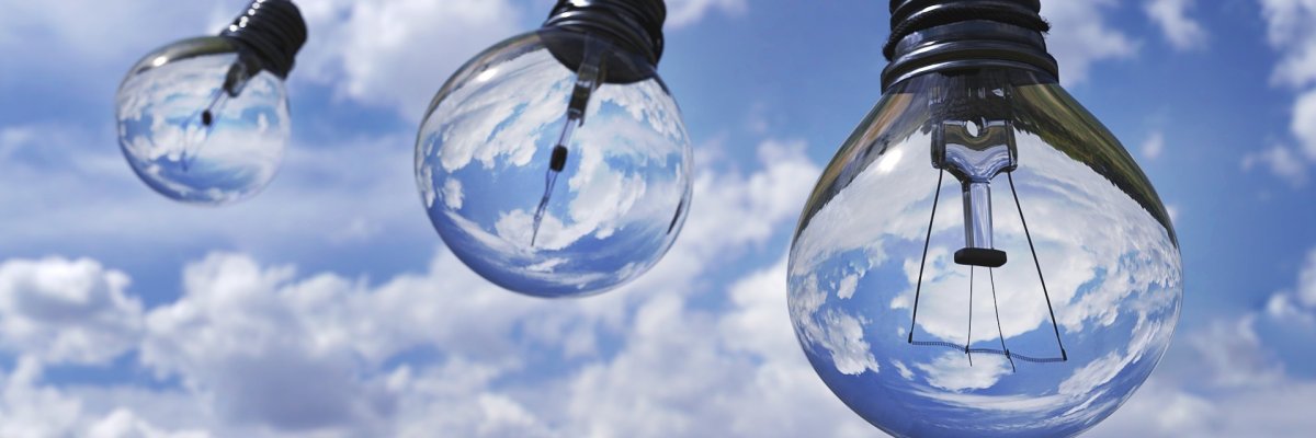 Three light bulbs in front of a blue sky