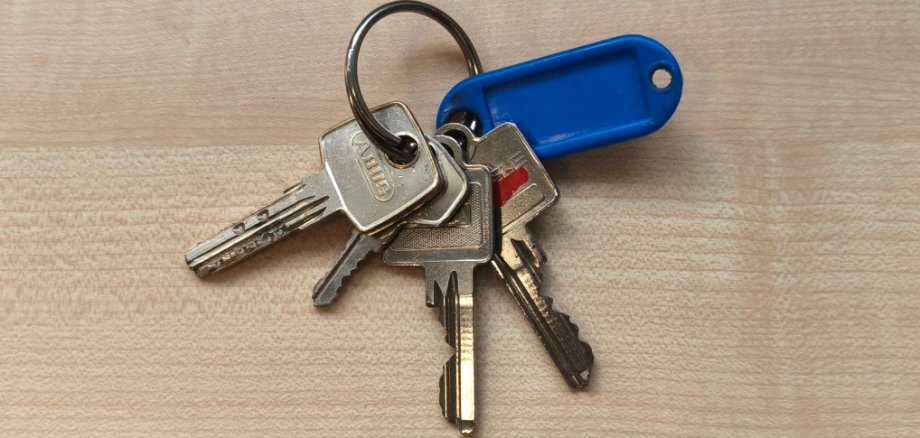 Keys Found on the Wetten Community Bus Four keys and a small blue tag are hanging from a keyring.