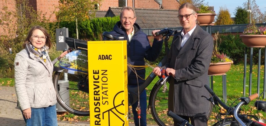 ADAC fiets service station Drie mensen staan naast het gele ADAC fietsservicestation in de Solegarten St. Jakob in Kevelaer en presenteren het nieuwe reparatiestation voor fietsen.