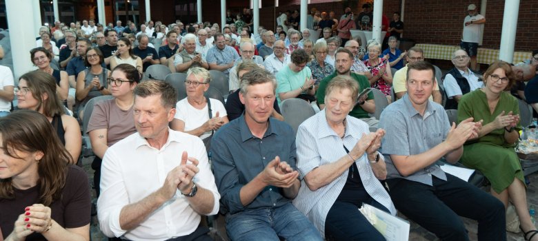 Вид на зал для заходів Форуму «Pax Christi», де близько 200 гостей, які беруть участь у «Вечорі для громадських організацій», аплодують.